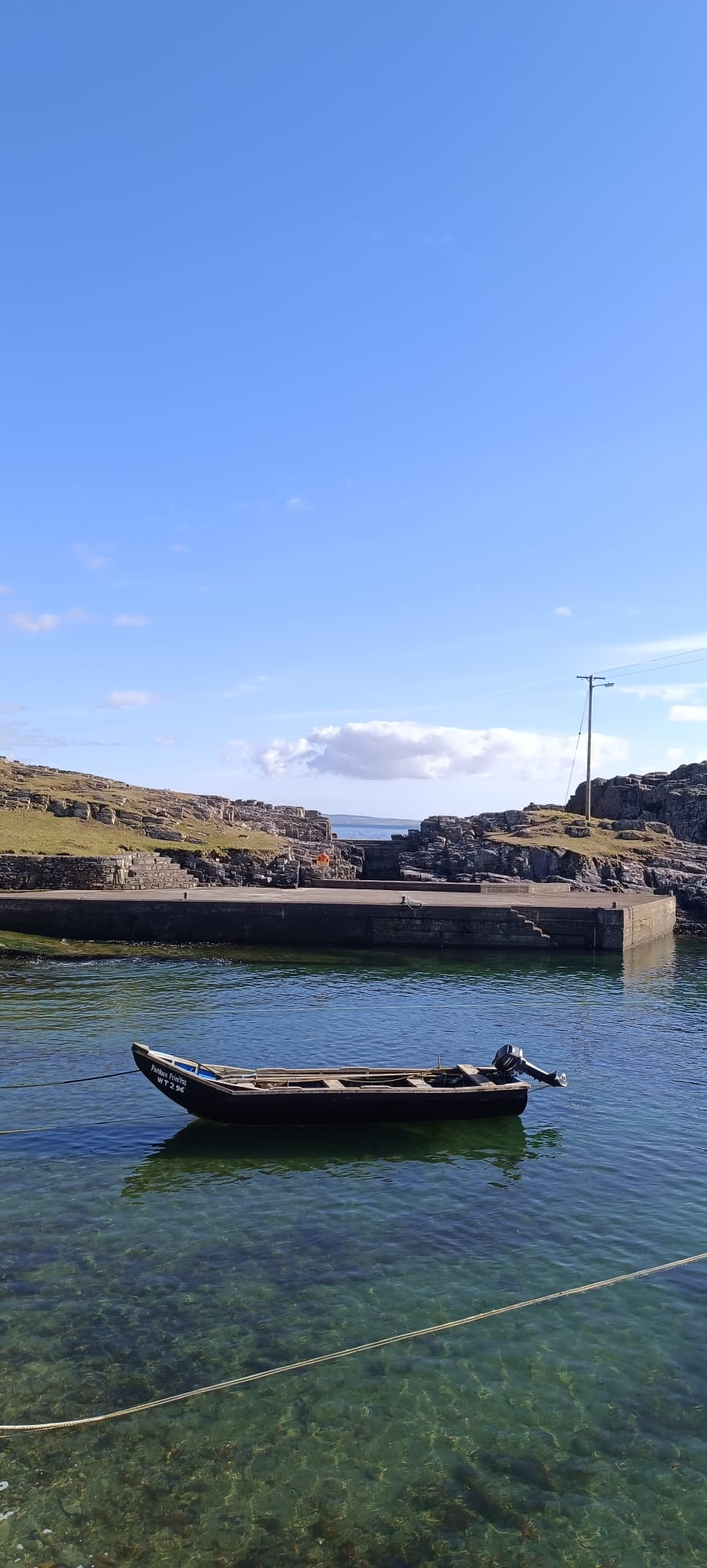Wooden boat in the harbour beneath a wide blue sky